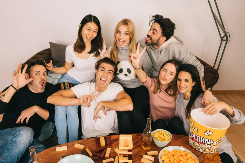 Grupo de amigos posando divertidos en el sofá durante una noche de entretenimiento con proveedor IPTV